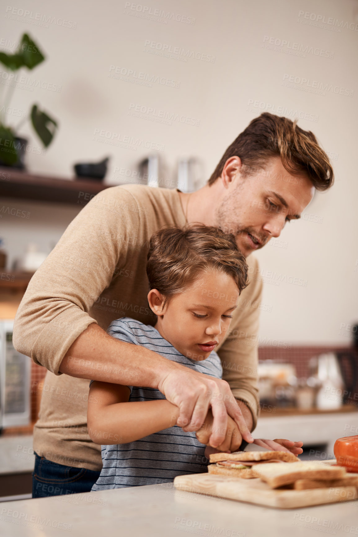 Buy stock photo Shot of a young boy making a sandwich with the help of his father