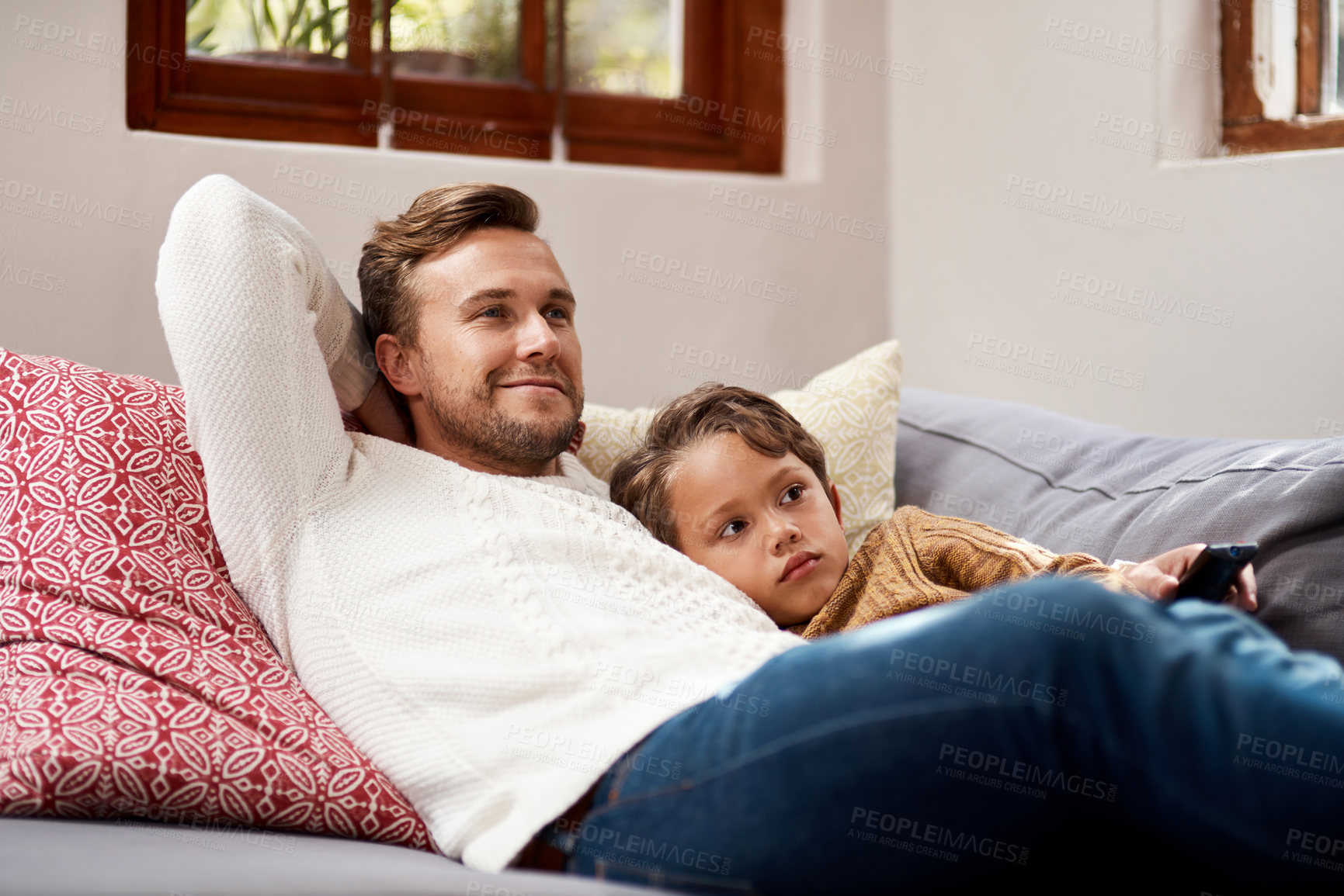 Buy stock photo Shot of a man and his son relaxing on the couch at home