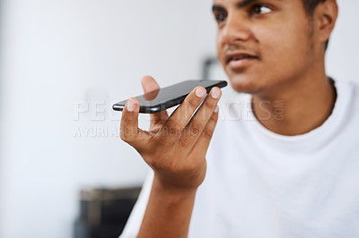 Buy stock photo Cropped shot of a young man talking over the phone while sitting at home