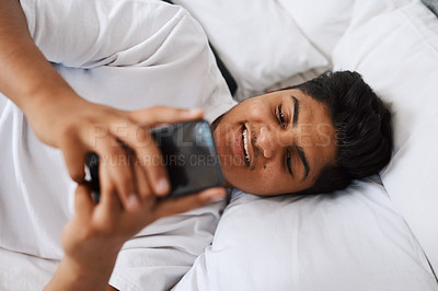 Buy stock photo Young man, and above with phone in bedroom for online communication, internet and social media. Happy, youth and smile with technology at home for text message, website and reading notification