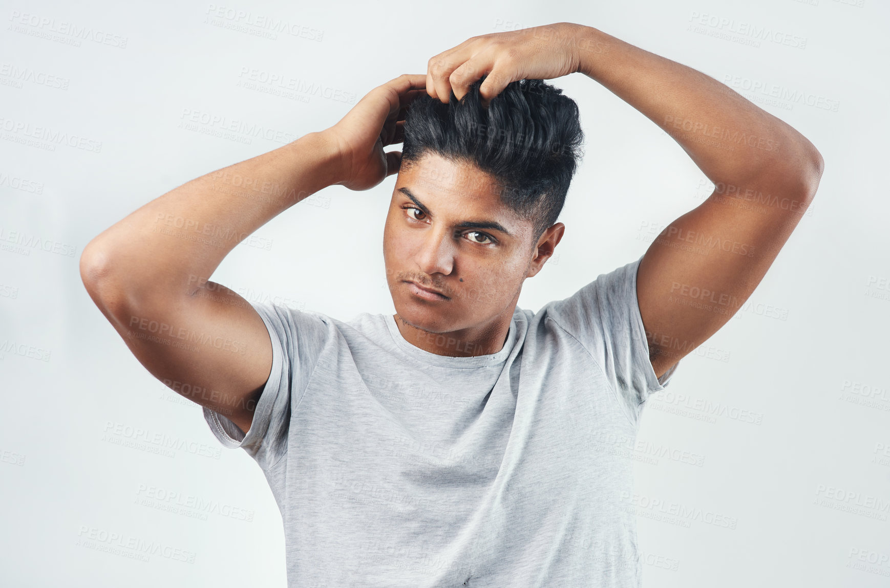 Buy stock photo Studio shot of a young man putting his fingers through his hair