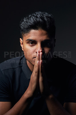 Buy stock photo Studio shot of a handsome young man sitting against a black background