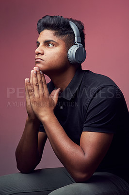 Buy stock photo Studio shot of a handsome young man wearing headphones