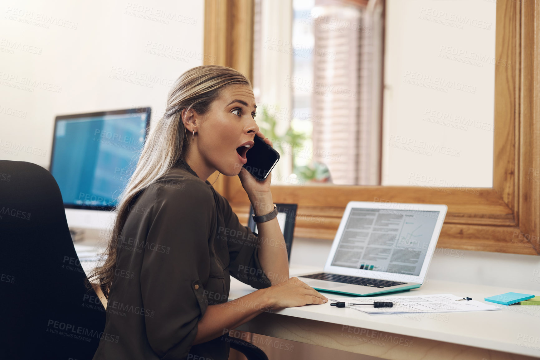 Buy stock photo Surprised, shocked and excited young businesswoman gossiping and listening to fake news on a phone call in the office. Amazed female gasping wow in disbelief with an oh my god expression on her face