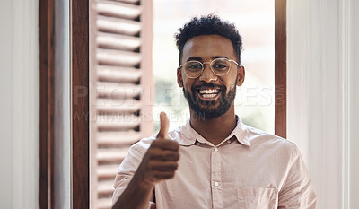 Buy stock photo Thumbs up, endorsing and thank you with a young man smiling, feeling positive and giving his approval while standing inside. Portrait of a happy male wearing glasses and giving his trust or support
