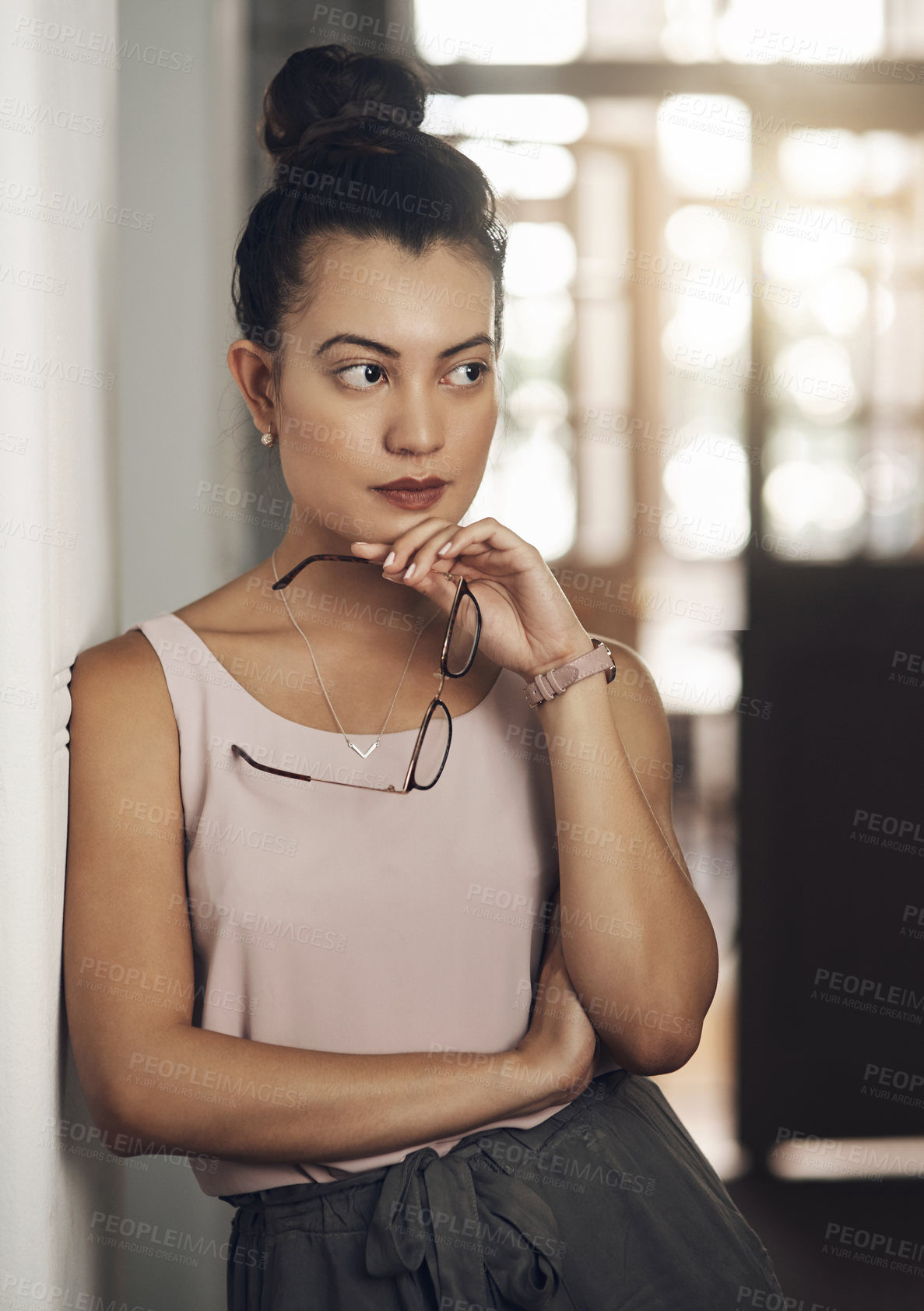 Buy stock photo Shot of a young businesswoman looking thoughtful in a modern office