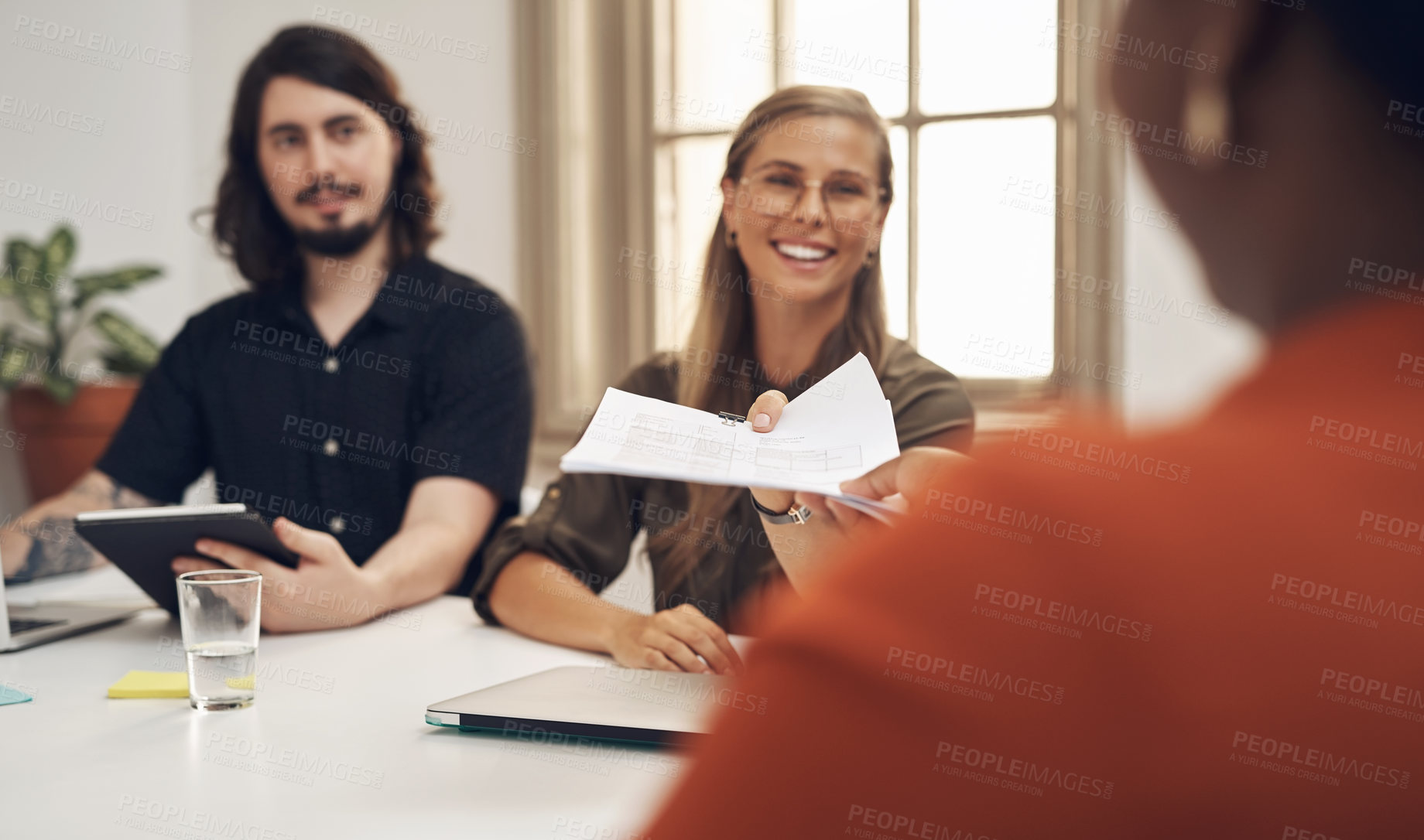 Buy stock photo Shot of businesspeople passing paperwork during a meeting in an office