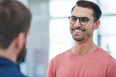Buy stock photo Shot of two young businessmen having a conversation in a modern office