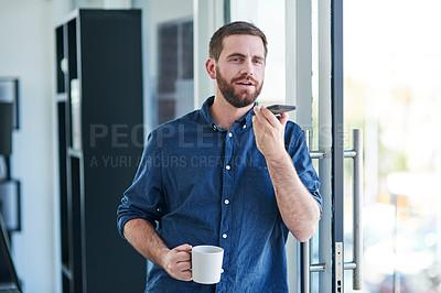 Buy stock photo Shot of a young businessman having coffee and using a smartphone in a modern office