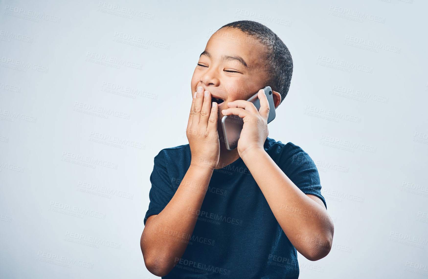 Buy stock photo Studio shot of a cute little boy looking amazed while using a smartphone against a grey background