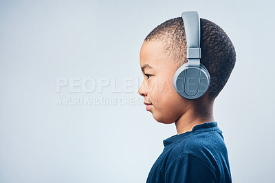 Buy stock photo Boy, child and headphones in studio, podcast and listening to sound on white background. Male person, kid and tech connect for hearing audio in profile, streaming radio and music playlist on mockup