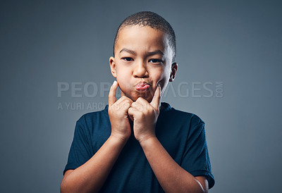 Buy stock photo Studio shot of a cute little boy making funny faces against a grey background
