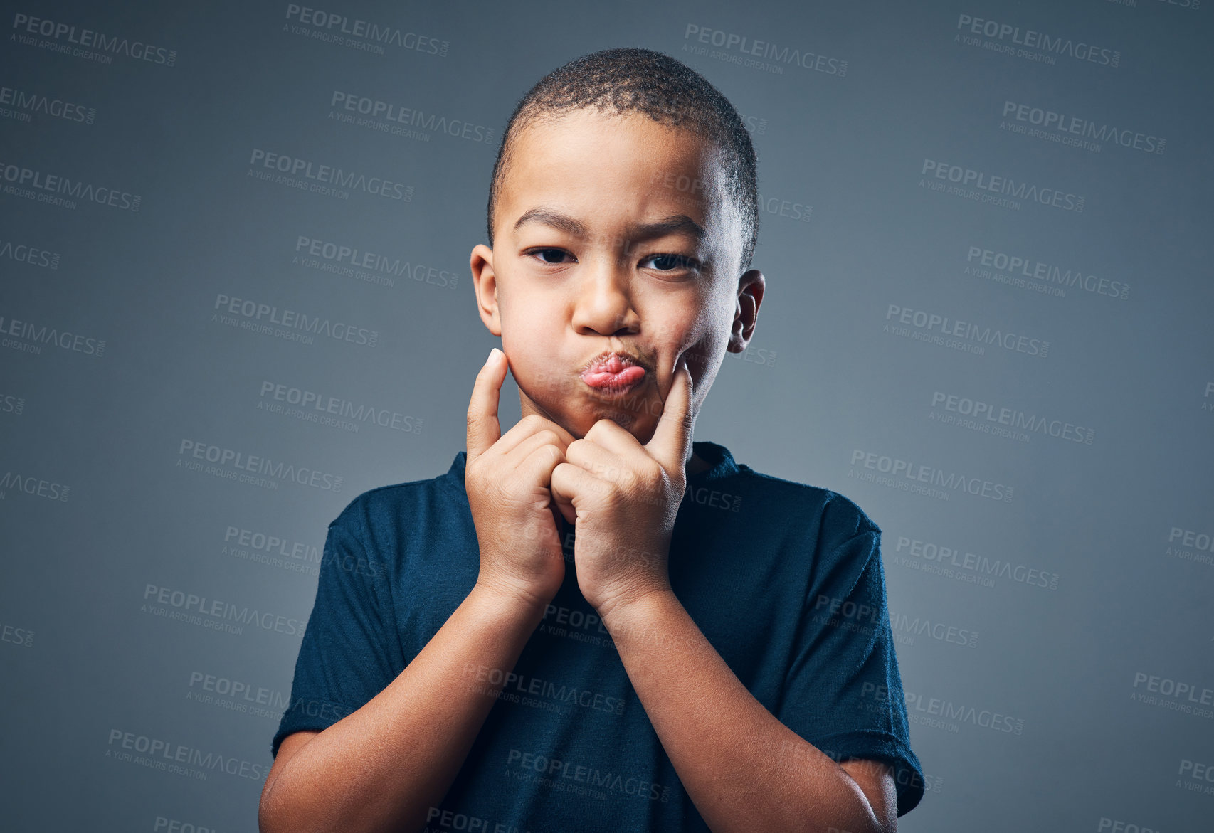 Buy stock photo Studio shot of a cute little boy making funny faces against a grey background
