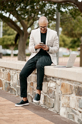 Buy stock photo Stylish, cool smiling businessman on a phone in the park outside in nature. Happy man texting, chatting or reading social media messages on a smartphone outdoors on a break from work with copy space