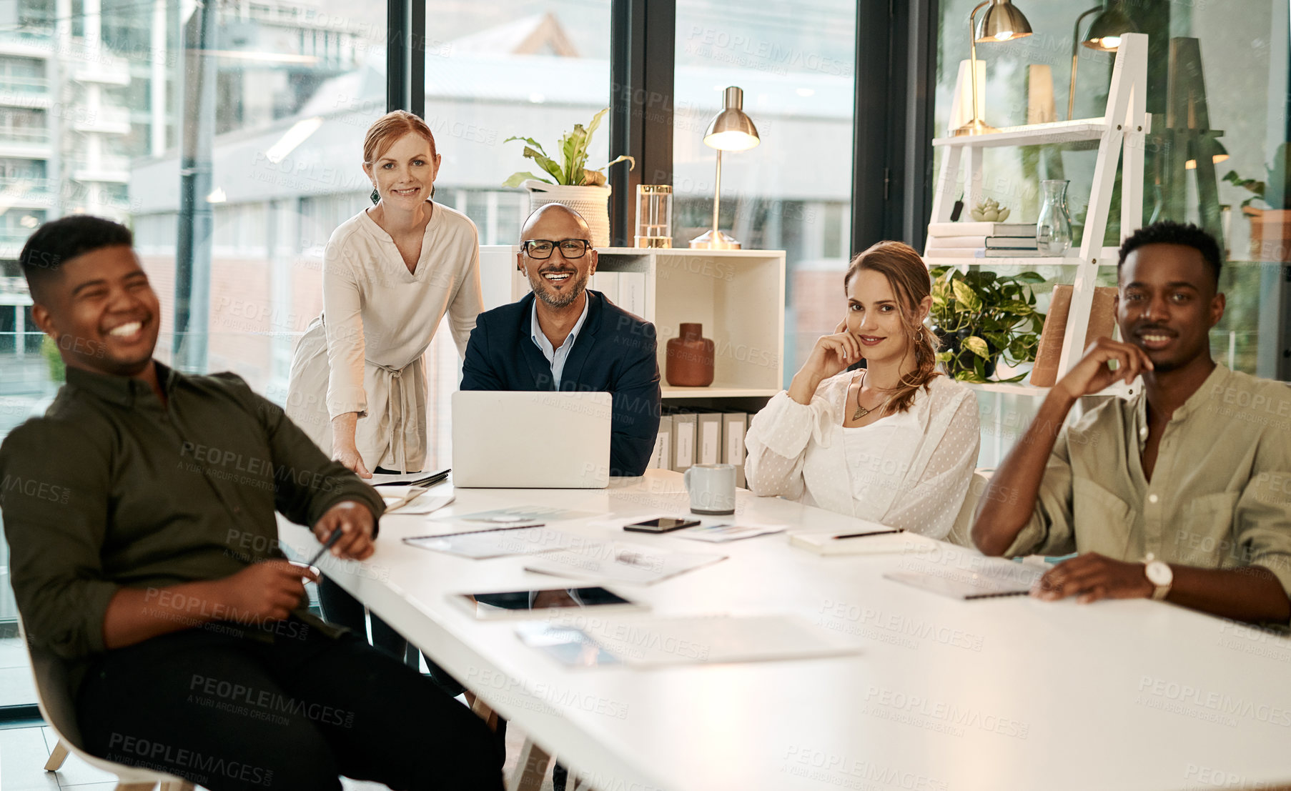 Buy stock photo Smiling, diverse and creative marketing team sitting in a boardroom meeting for startup business or company. New happy young people getting coaching from mature entrepreneur leaders using a laptop   