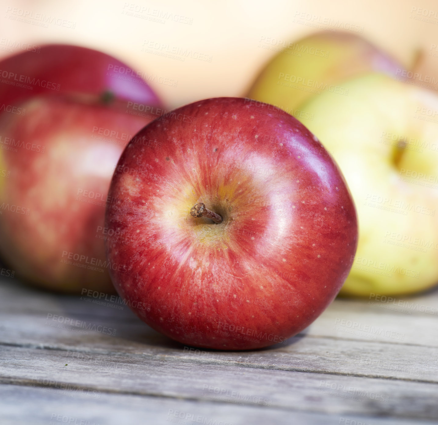 Buy stock photo Closeup of fresh red apples on a table. Delicious and organic fruit picked when ripe and in season to enjoy with vitamins for a healthy immunity. Nutritious produce for a vegan or vegetarian diet
