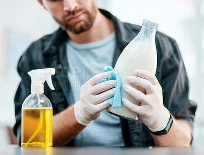 Buy stock photo Shot of a young man disinfecting a bottle pf milk at home