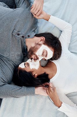 Buy stock photo Skincare, love and face mask with kiss and couple from above for beauty, cosmetics and diy spa treatment. Wellness, collagen and detox facial with man and woman in bedroom at home for self care