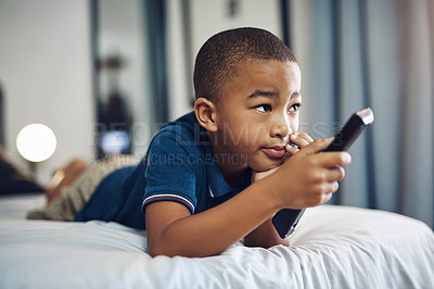 Buy stock photo Bedroom, watching tv and child with remote, house and streaming of cartoon, channel and entertainment. Home, youth and subscription to favorite series, bed and boy with controller and choice of show