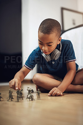Buy stock photo Shot of a young boy playing with toy soldiers at home