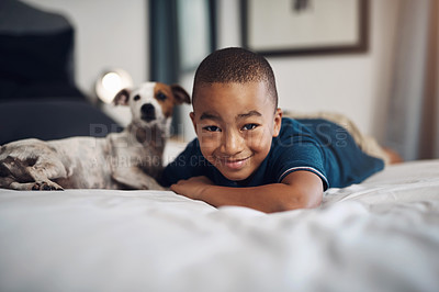 Buy stock photo Shot of an adorable little boy playing with his pet dog on the bed at home