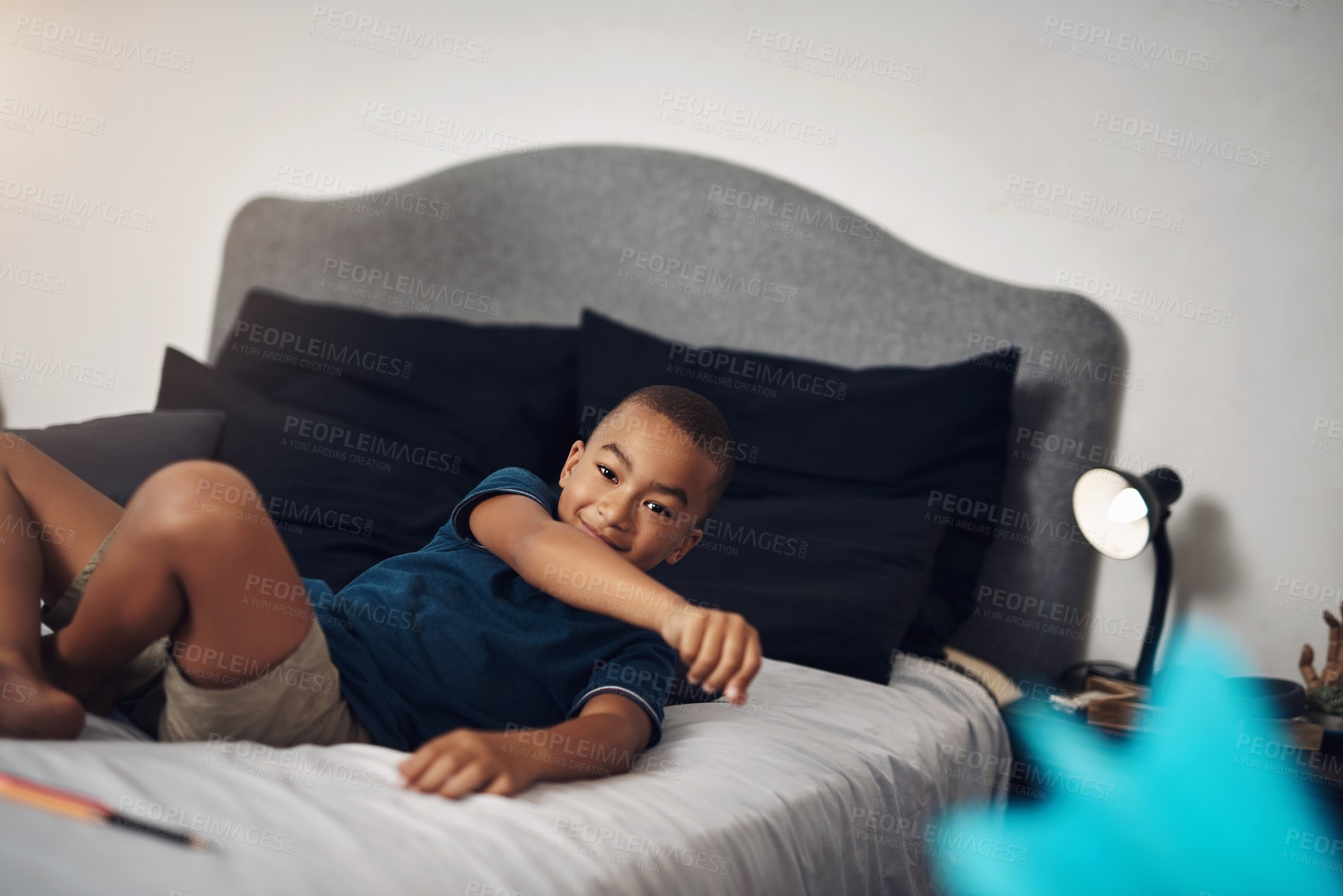 Buy stock photo Shot of a young boy lying on his bed