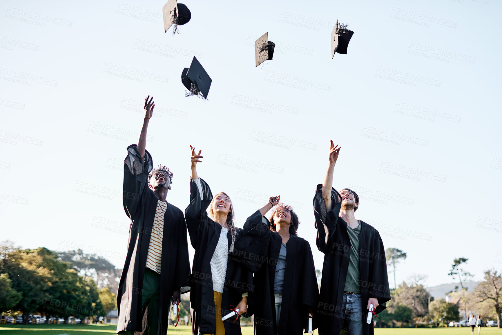 Buy stock photo Students, graduation and celebration with hats in air for qualification, achievement or certificate at campus. Happy group, excited people or graduates with smile for milestone, diploma or degree