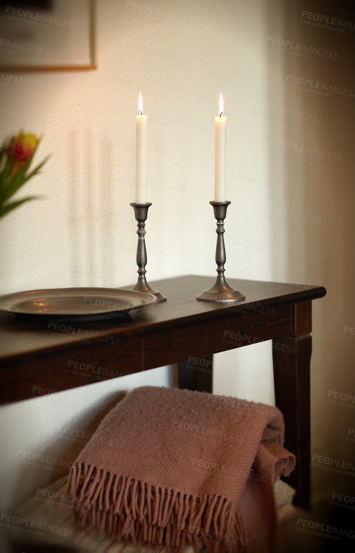 Buy stock photo Elegant and decorative lit candles on a wooden table at home. Woven throw and house decorations for aroma, good scent and to warm up a room. Cosy decor for a modern apartment
