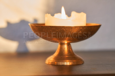 Buy stock photo Elegant and decorative lit candle on a table at home. Beautiful house decorations used for aroma, good scent and to brighten up a dark room. Candles represent light, illumination, and purification