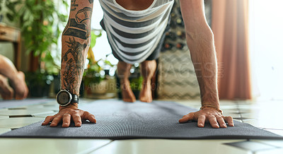 Buy stock photo Shot of an unrecognisable young man doing planks during a yoga routine at home