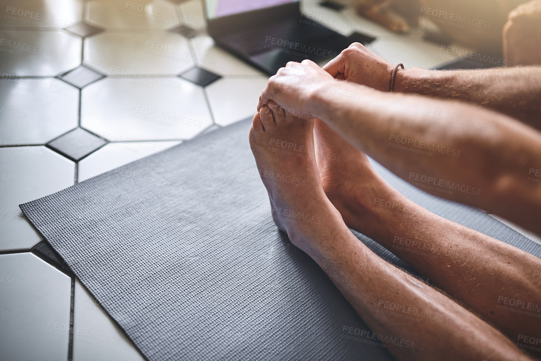 Buy stock photo Shot of an unrecognisable man using a laptop while going through a yoga routine at home