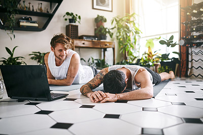 Buy stock photo Shot of two men taking a break after going through an online yoga routine at home
