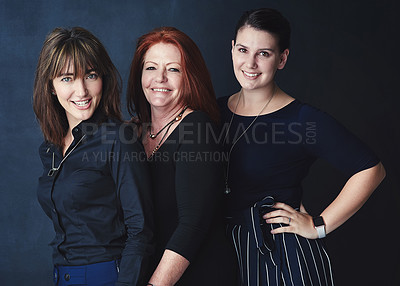 Buy stock photo Shot portrait of three businesswomen standing together against a dark background