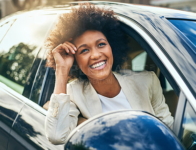 Buy stock photo Shot of a cheerful young businesswoman driving in a car to work with her arm leaning out of the vehicle during the day