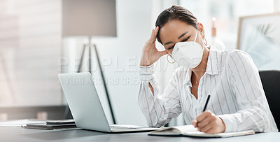 Buy stock photo Shot of a masked young businesswoman looking stressed while working at her desk in a modern office