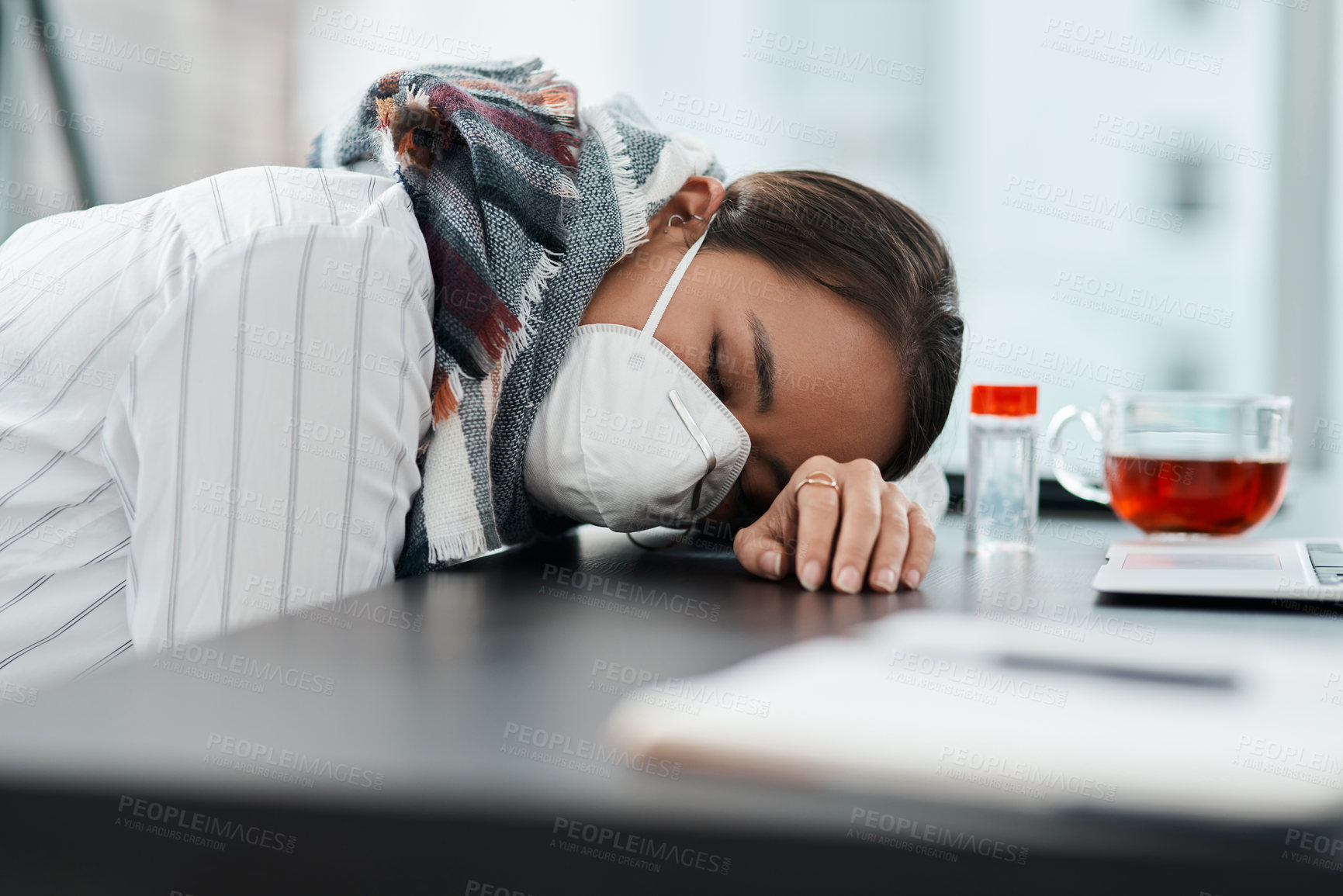 Buy stock photo Shot of a masked young businesswoman sleeping at her desk in a modern office