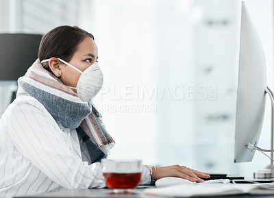 Buy stock photo Shot of a masked young businesswoman using a computer in a modern office