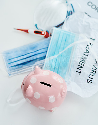 Buy stock photo Shot of a piggybank and coronavirus props against a white background