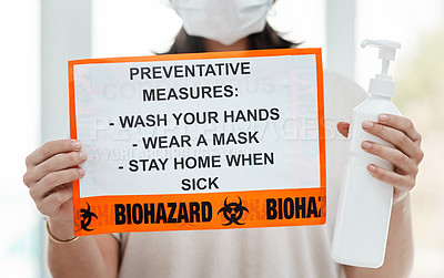 Buy stock photo Shot of a woman holding up a sign with a list of COVID-19 prevention measures
