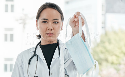 Buy stock photo Cropped shot of a medical practitioner holding up a face mask