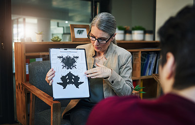Buy stock photo Shot of a mature psychologist conducting an inkblot test with her patient during a therapeutic session