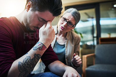 Buy stock photo Shot of a young man being comforted by his psychologist during a therapeutic session