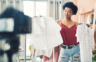 Buy stock photo Shot of a woman recording herself while holding up two clothing items
