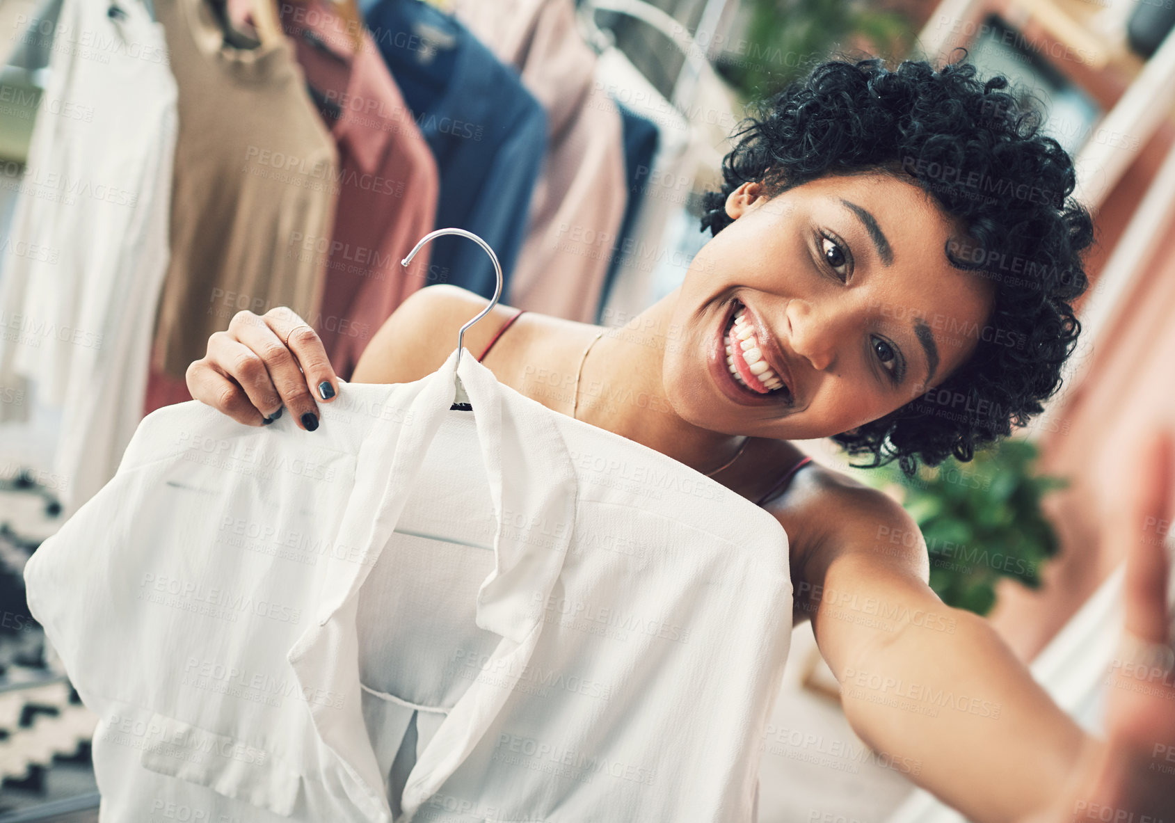 Buy stock photo Cropped shot of a woman holding up a shirt towards the camera