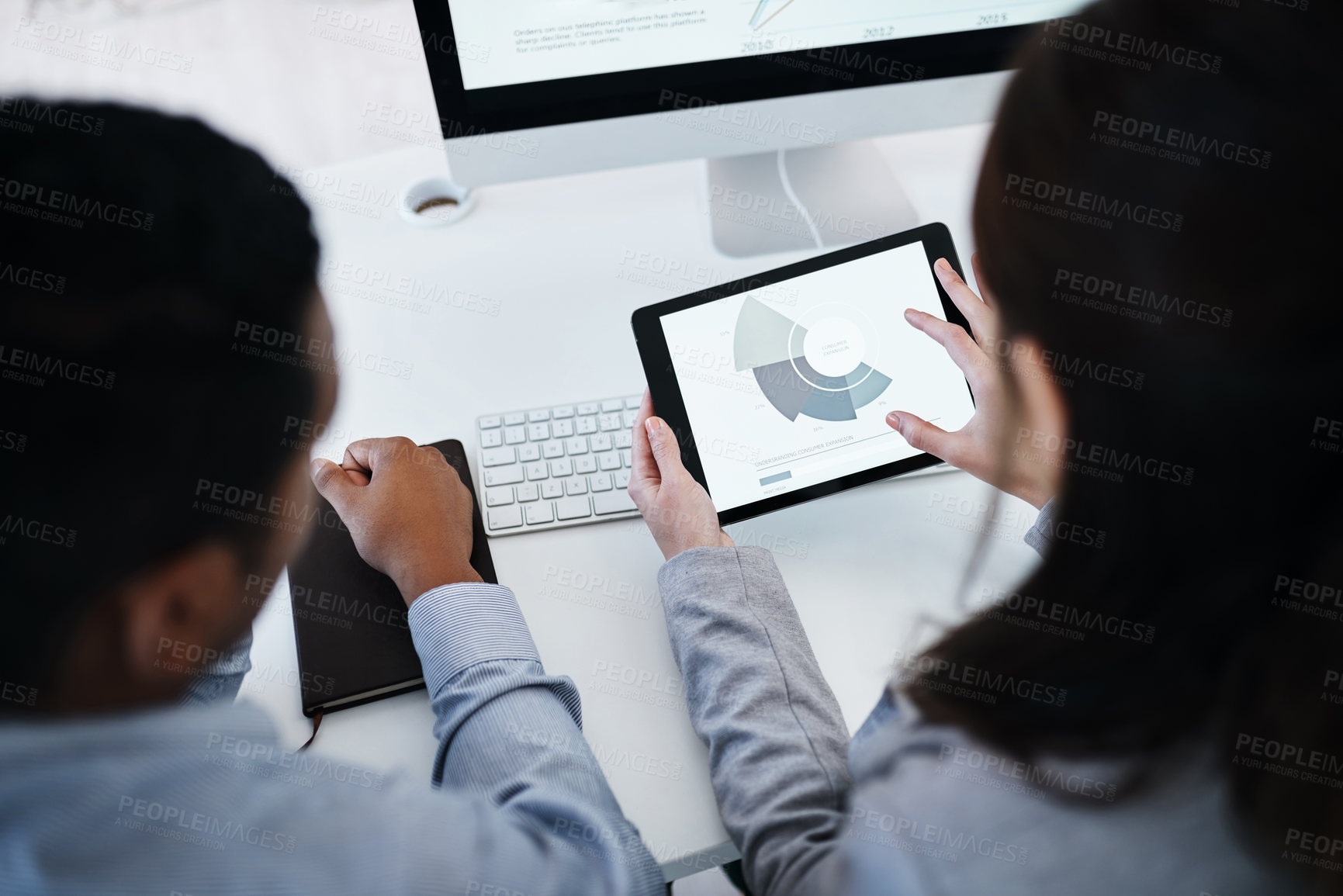 Buy stock photo Shot of a young businessman using a digital tablet to analyse financial data in a modern office