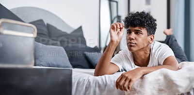 Buy stock photo Shot of a young man lying on his bed and analysing his hair