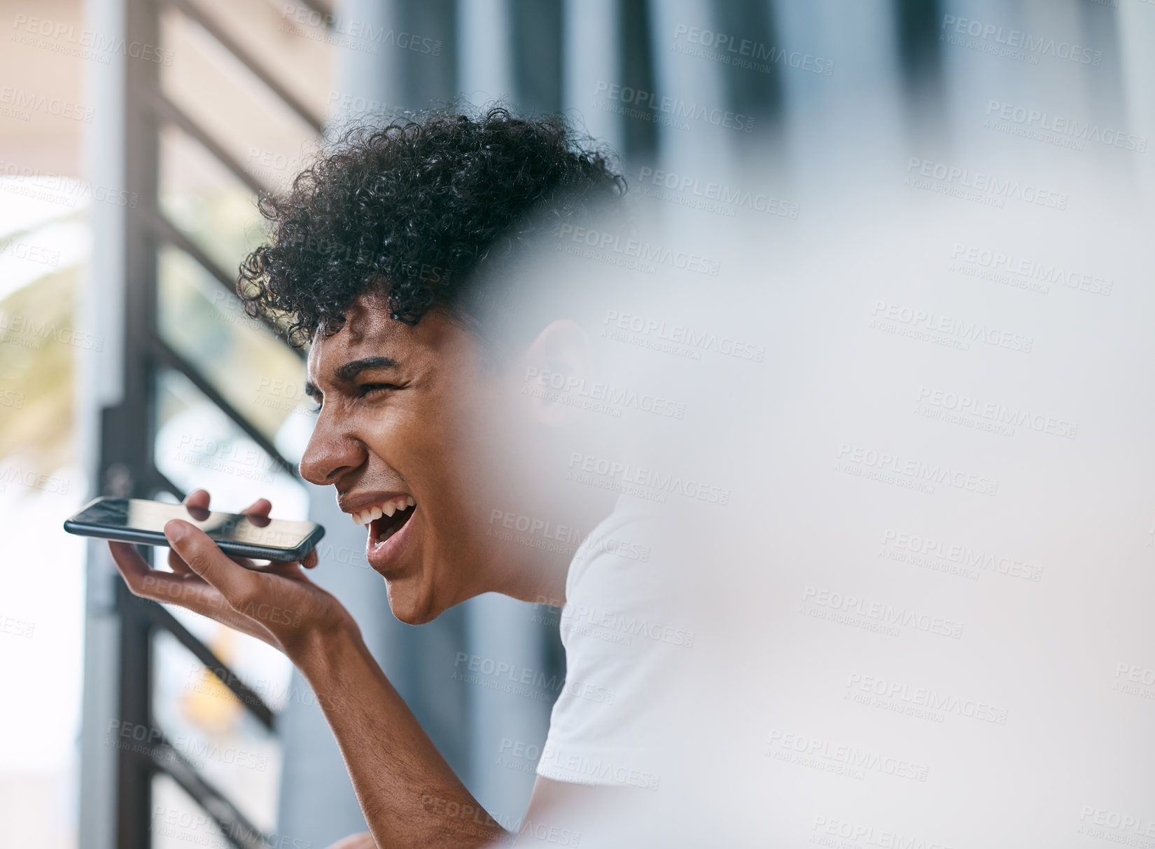 Buy stock photo Shot of a young man looking out of a window and using a smartphone at home