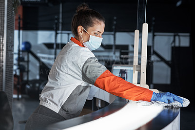 Buy stock photo Shot of a young woman cleaning the reception desk in a gym