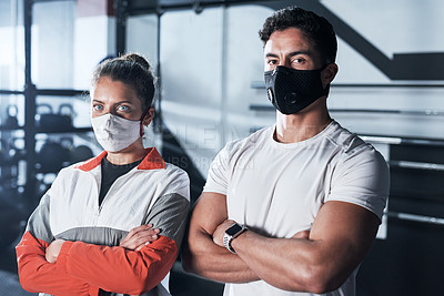 Buy stock photo Portrait of two sporty young people wearing face masks in a gym