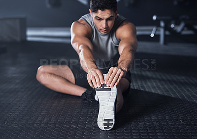 Buy stock photo Shot of a muscular young man exercising in a gym